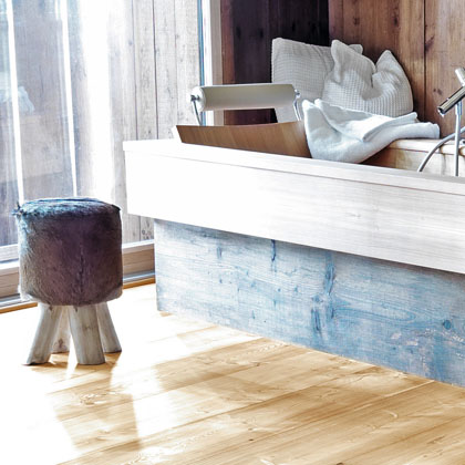 Badewanne aus Holz mit rustikaler Holzverkleidung und hellem Parkettboden