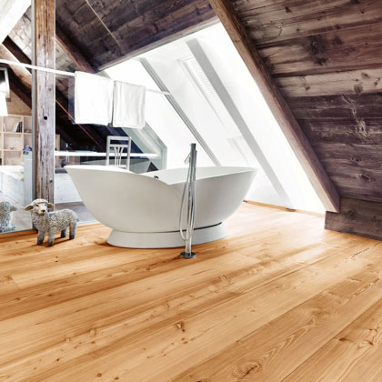 Bad in der Dachstube mit offener Holzverkleidung, dazu ein heller Parkettboden