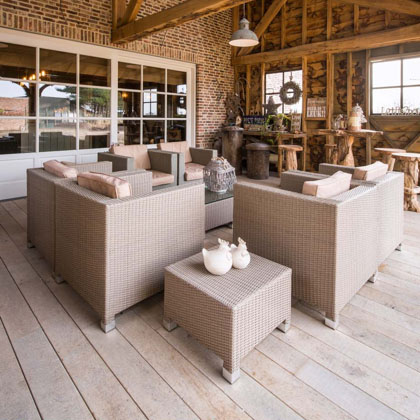 Terrasse mit Holzboden und passenden, hellbraunen Möbeln